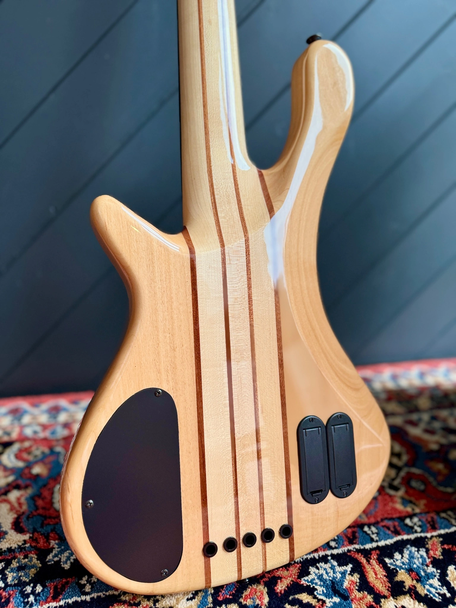 Rear body detail showing the layered neck-through construction and electronics covers.