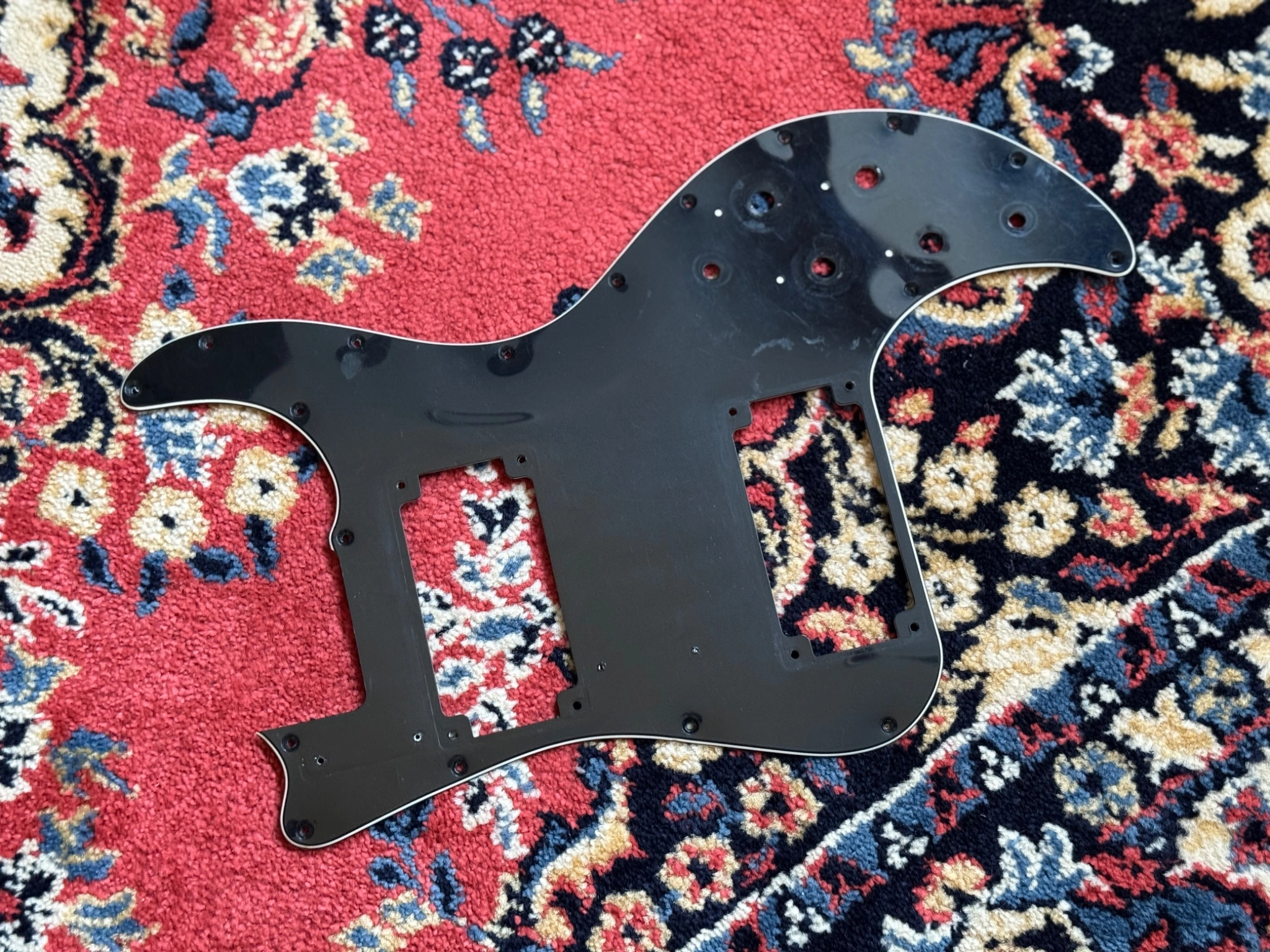 Underside of the pickguard showing visible scuffs and marks.