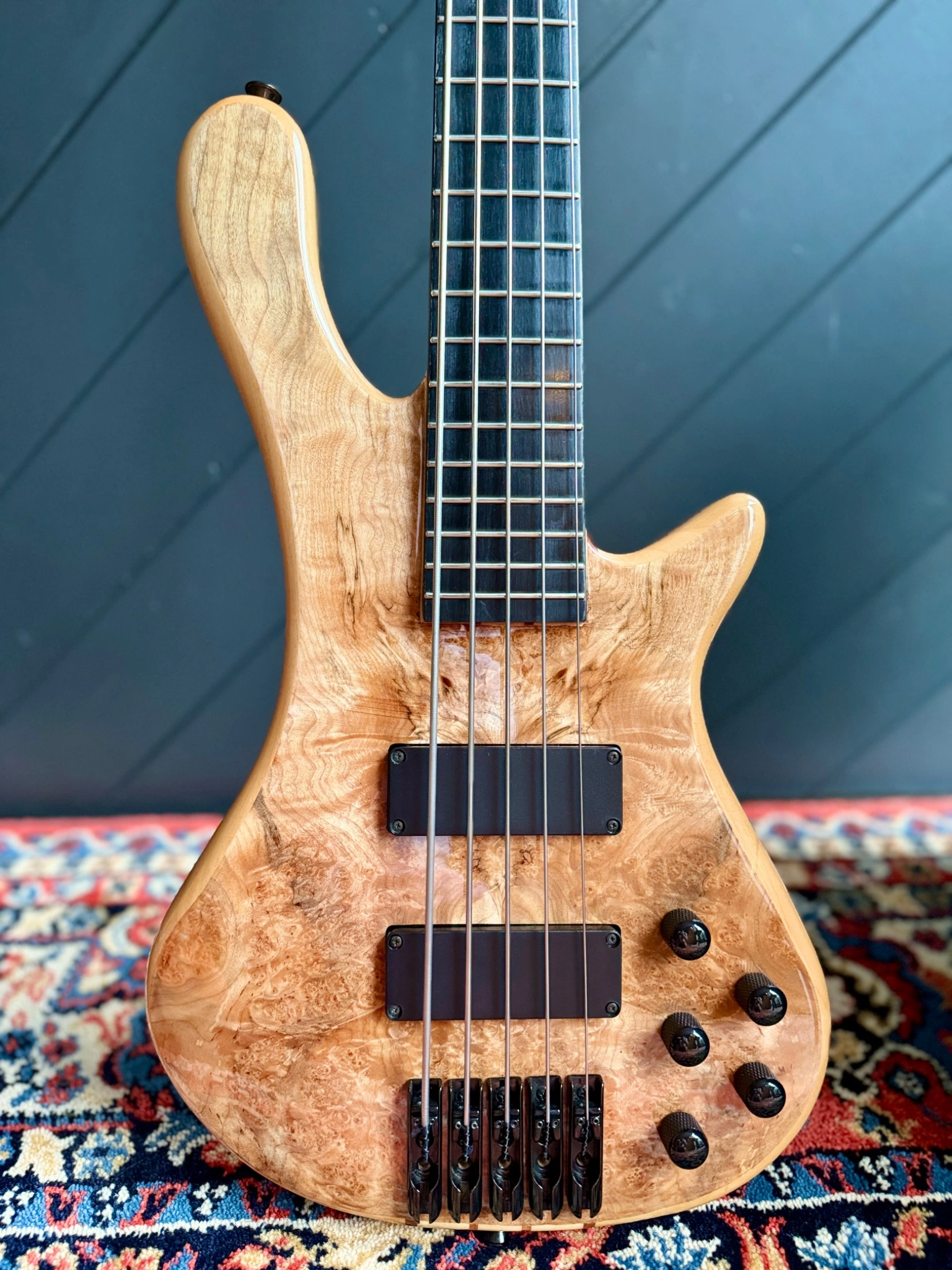 Front body detail showing the burl maple veneer, soapbar pickups and controls.