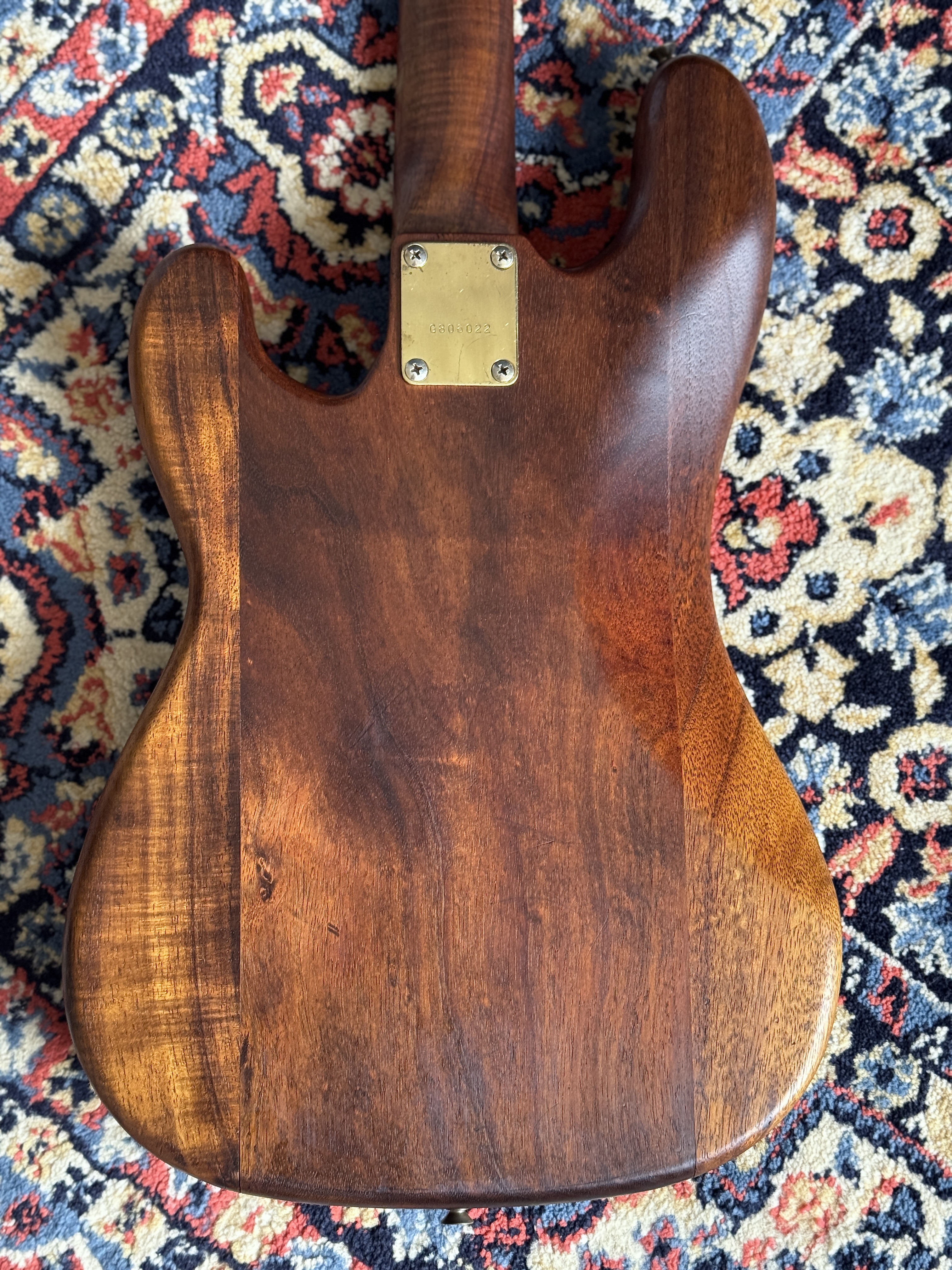 Figured back of the Greco bass with neck plate